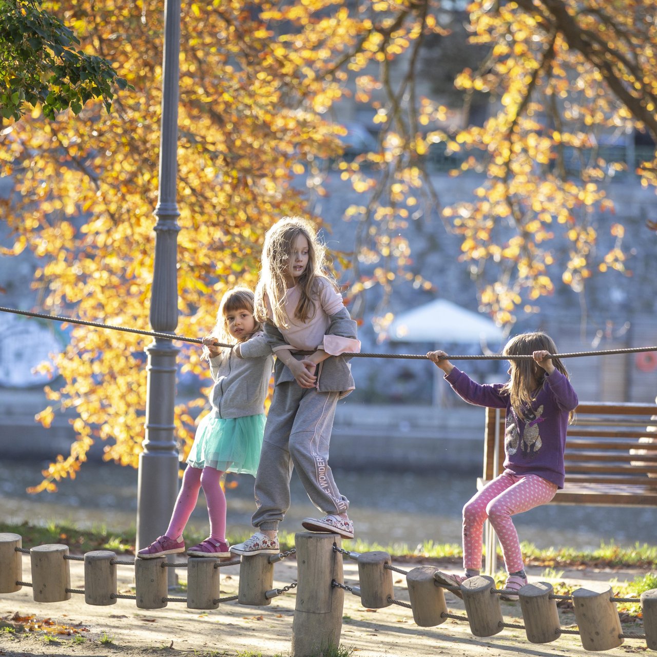 Drei Mädchen klettern auf dem Spielplatz.