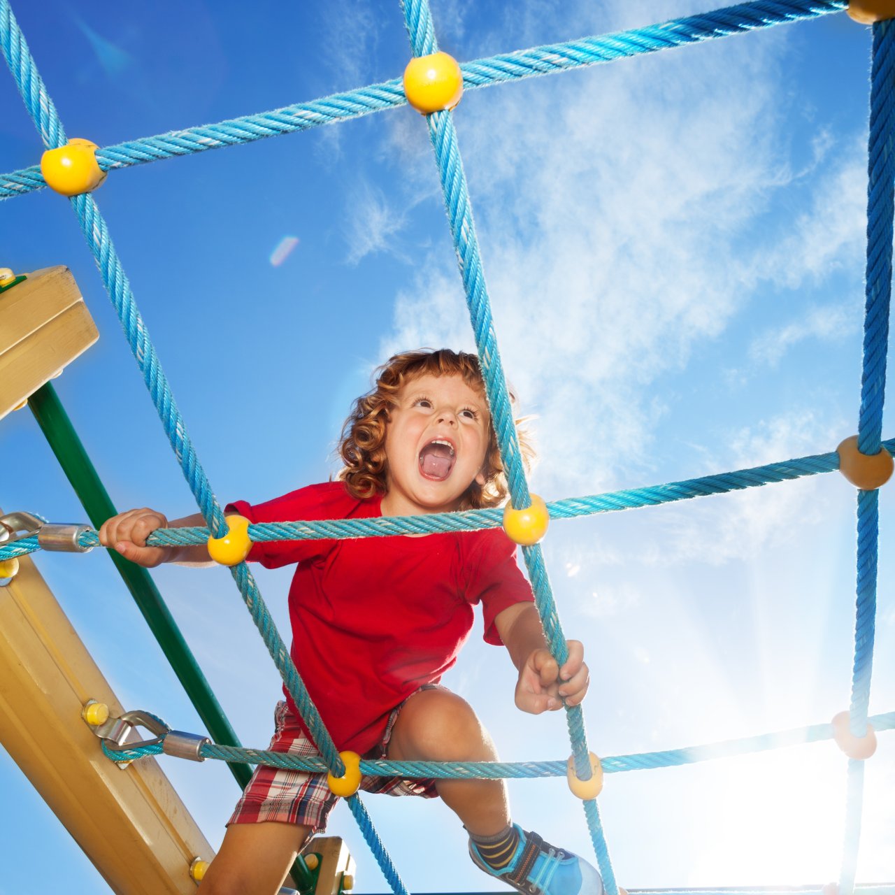 Kind hat Freude auf dem Klettergerüst